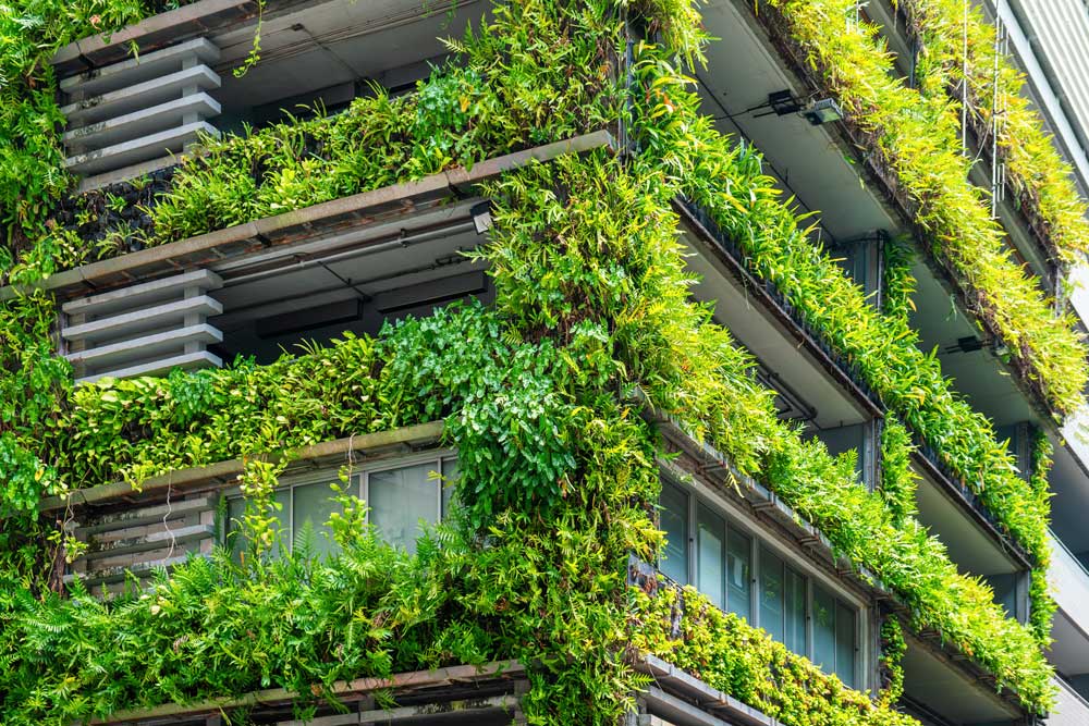 Fachada de edificio moderno con jardín vertical y plantas naturales