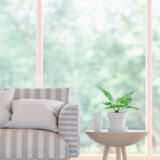 sofá con ventana y jardín de fondo