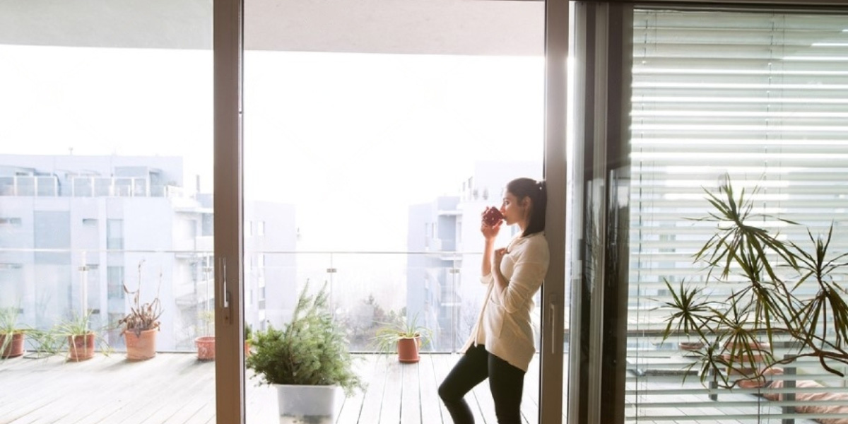 Mujer tomando café en la terraza de un hogar