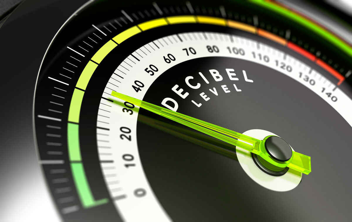 Primer plano de un medidor de decibelios con la aguja indicando un nivel bajo, representando la medición del ruido y el aislamiento acústico.