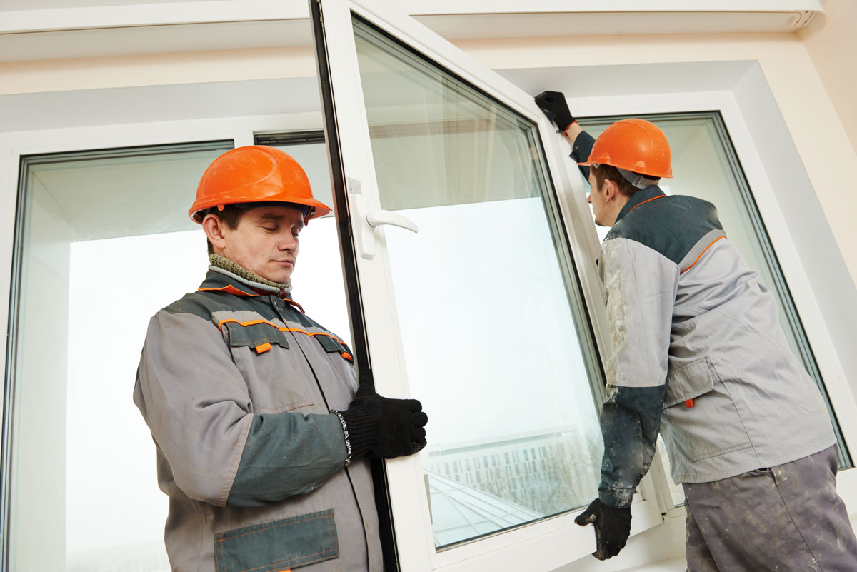 Operarios instalando nuevas ventanas con acristalamiento eficiente