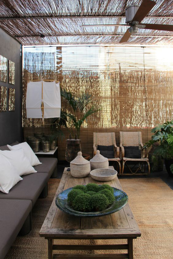Zona chill-out con techo de cañizo, sofá de líneas rectas y decoración natural