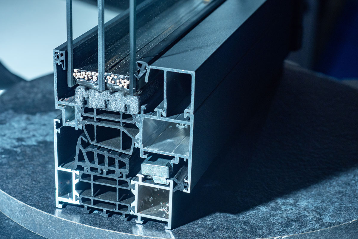 Detalle de marco de ventana con sección de doble acristalamiento mostrando aislamiento térmico interior