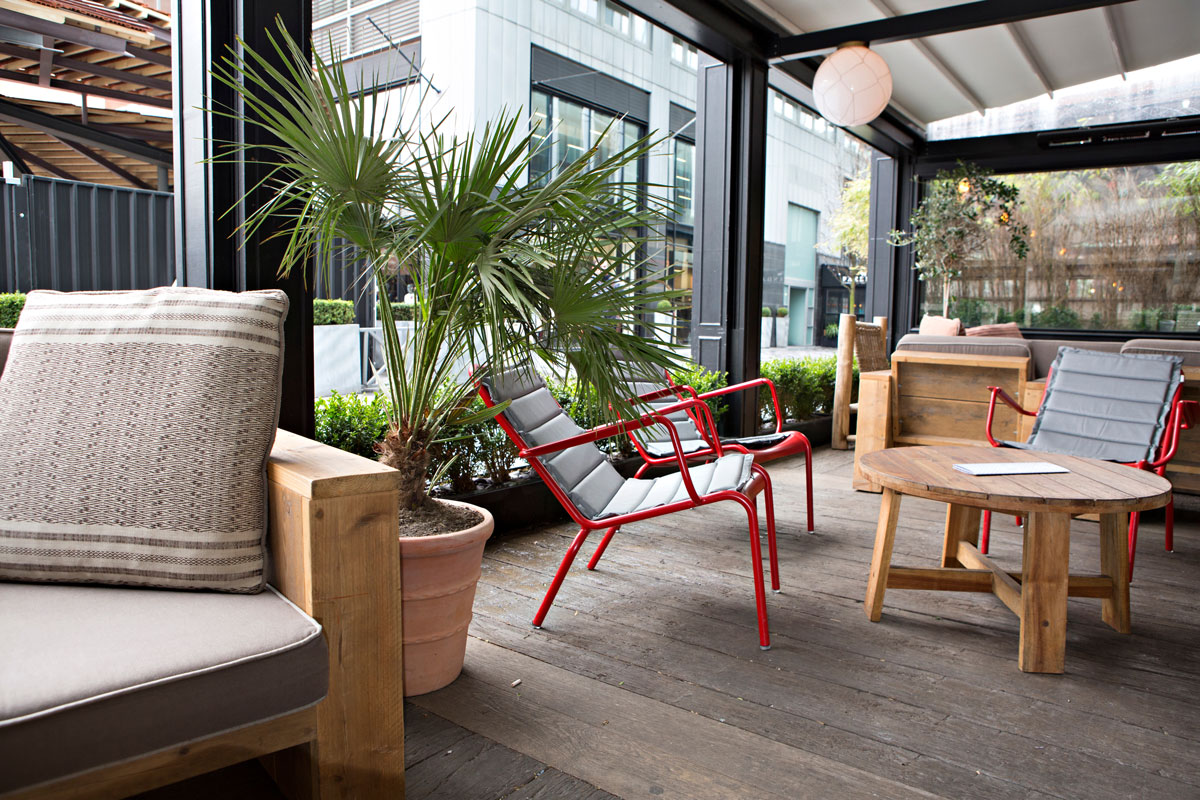 Terraza acristalada confortable con mobiliario y cerramiento de vidrio
